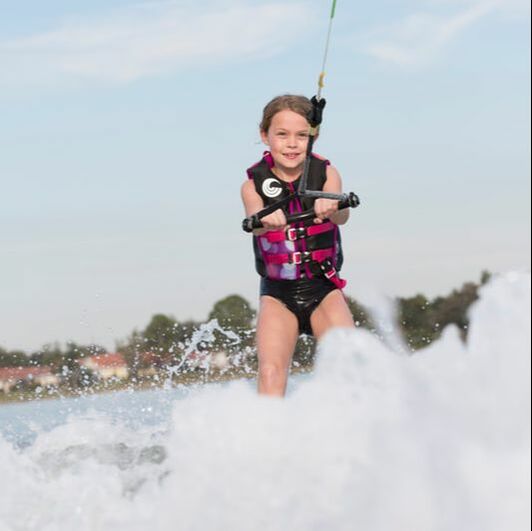Young girl waterskiing while wearing a Connelly vest